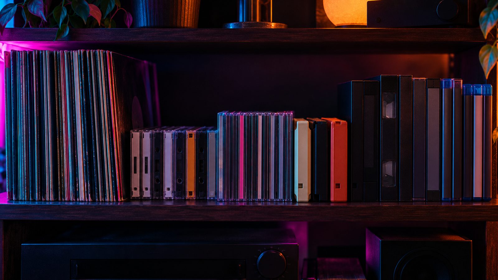 A home shelf of records, cassettes, CDs, 8-tracks, VHS tapes and Blu-ray cases in neon light